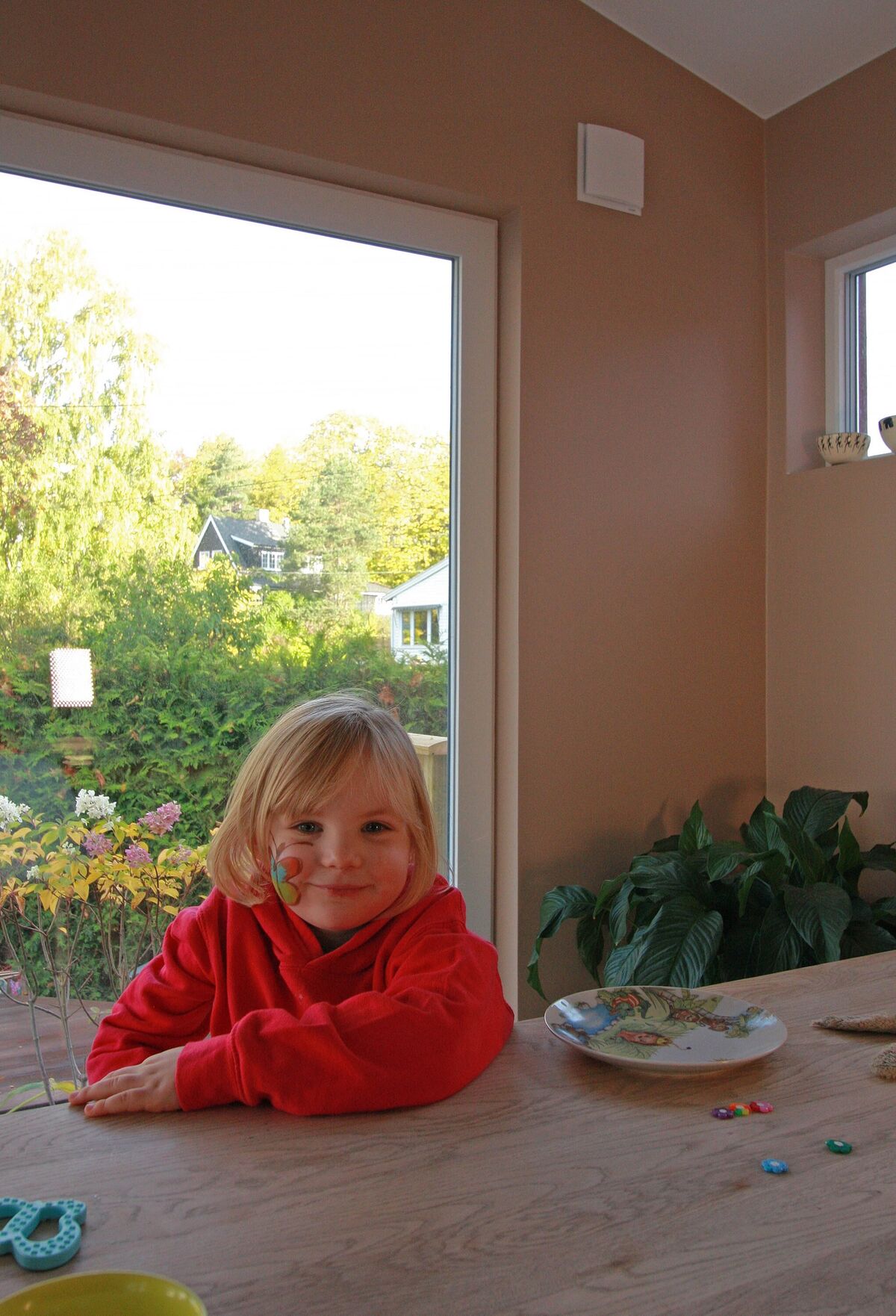 Larissa med barna utenfor sitt nyrenoverte hus. De er godt fornøyde med balansert ventilasjon som kun sees ved to ventiler rett ved vinduene. 